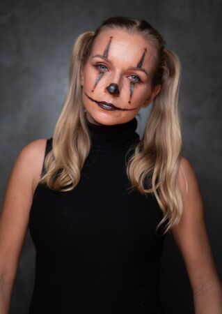 Halloween clown woman portrait posing over concrete wall backgroundの写真素材