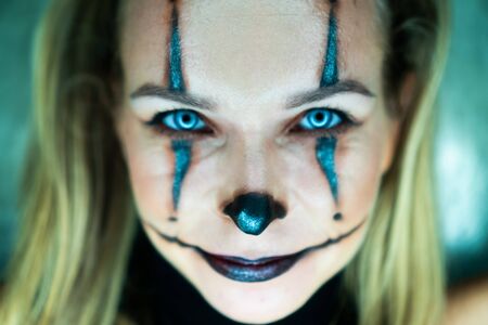 Halloween clown woman portrait posing over concrete wall backgroundの写真素材
