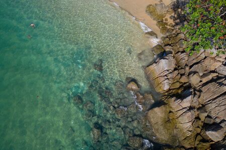 Aerial drone top view of turquoise sea surface with stones and rocks in waterの写真素材