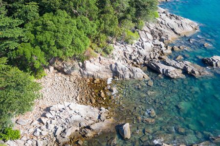 Aeria dronel view of rocky shore with turquoise sea waterの写真素材