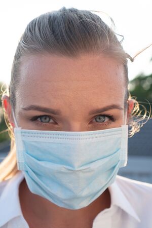 Portrait of woman in protective mask against flu and viruses outdoors. Helathcare, flu epidemic, dust allergy, virus protection, air pollution conceptの写真素材
