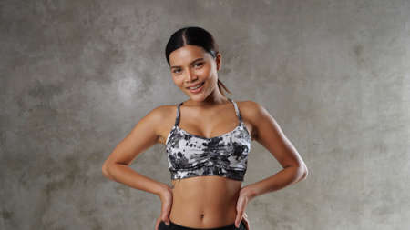 Beautiful young Asian woman at the gym. Happy girl spending her free time at the sport centreの写真素材