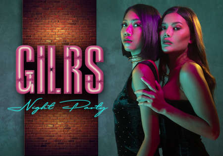 Portrait of two young cute Asian women in elegant dresses on the pink and yellow neon lights. Sexy disco women, girls night party banner conceptの写真素材