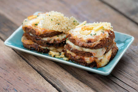 Pan fried crispy eggplant with parmesan cheese crust isolated on wooden table