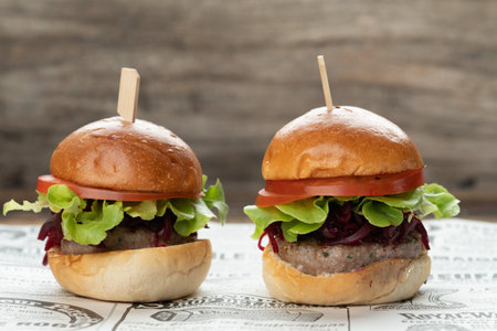 Two mini beef burgers with beetroot relish. Beef patties on two brioche buns with lettuce and beetrootの写真素材