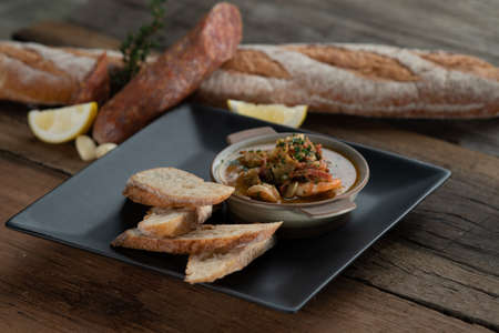 Gambas Pil Pil - Sizzling prawns with chili and garlic served with bread on the side isolated on wooden rustic tableの写真素材
