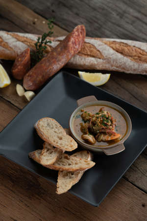 Gambas Pil Pil - Sizzling prawns with chili and garlic served with bread on the side isolated on wooden rustic tableの写真素材