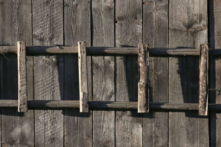 Old ladder  hanging on the wooden wallの写真素材