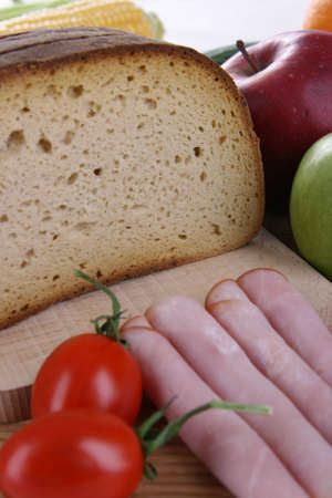Bread in slices with vegetables and hamの写真素材