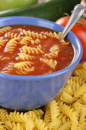 Red dressing in blue bowl with pasta の写真素材