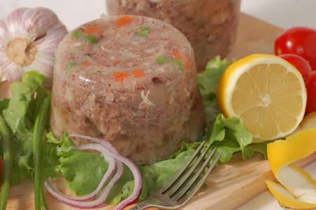 Meat jelly with vegetables on a meat-boardの写真素材