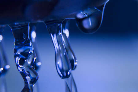 Drops of liquid water on the blue background