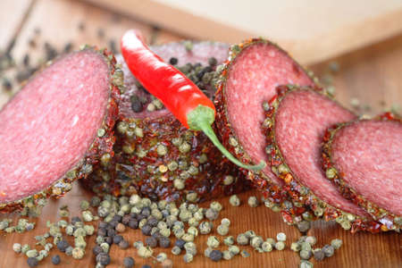 Chili and slices of salamiの写真素材