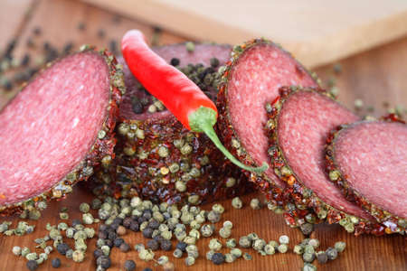 Chili, pepper and slices of salamiの写真素材