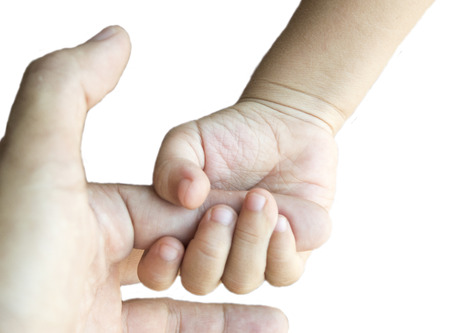 a parent holds the hand of a small childの写真素材
