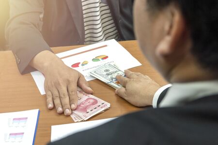 Business man holding USD dollars and yuan RMB money sharing for exchange investment.の写真素材