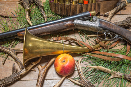 Hunting still life with hunting rifle, antlers and apple.