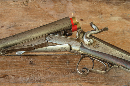 Old gun on a wooden background, close-up, vintage style