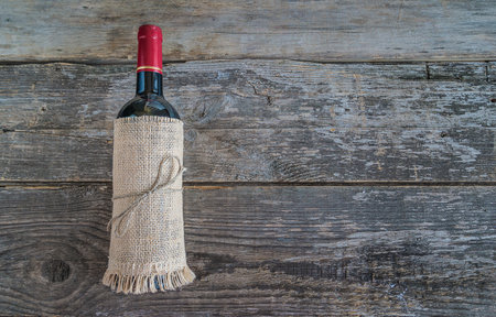 Red wine bottle on wooden background. Top view with copy space.の写真素材