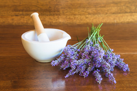 Mortar and pestle with lavender flowers on wooden tableの写真素材