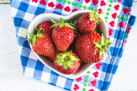 fresh strawberries in a bowl on a white wooden background. tinting. selective focusの写真素材