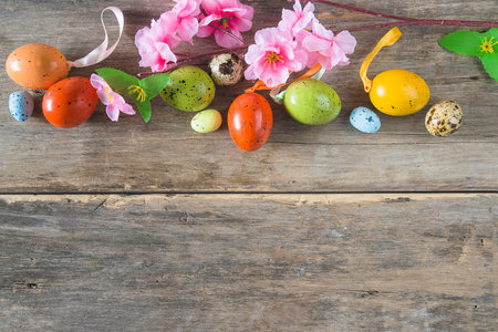 Easter eggs and spring flowers on wooden background with copy space.の写真素材