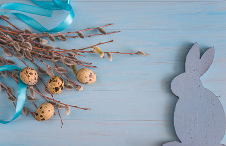 Easter eggs and willow branches on a blue wooden background.の写真素材