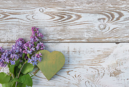 Lilac flowers and heart on wooden background. top view with copy spaceの写真素材