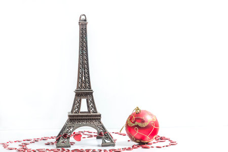 Eiffel Tower and red Christmas ball isolated on white background.