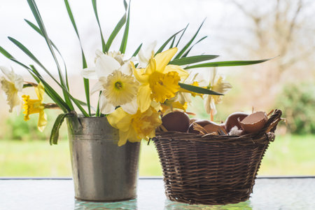 Easter eggs in basket with daffodils and narcissus