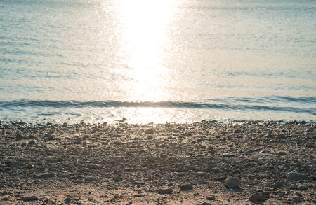 Sunset on the beach in the summer. The sun is reflected in the water.