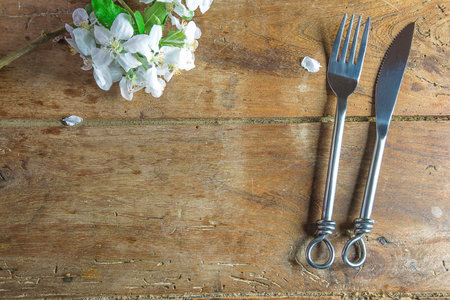Vintage cutlery and spring flowers on rustic wooden tableの写真素材