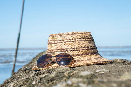 Straw hat and sunglasses on the beach. selective focus.の写真素材