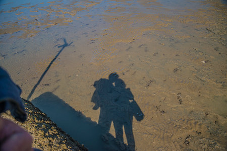 Shadow of a couple on the bank of the river in winter.の写真素材