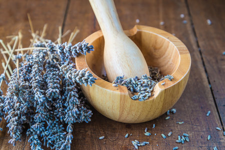 Dried lavender in wooden bowl and spoon on old wooden tableの写真素材