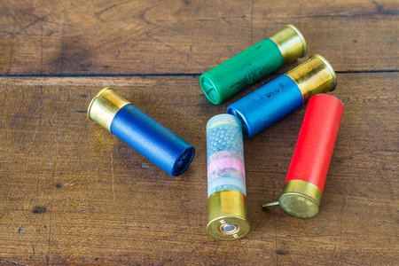 Bullets on wooden background. Cartridges of different sizes and colors.