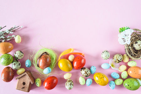 Easter composition with colorful eggs and birdhouse on pink background. Flat lay, top view.