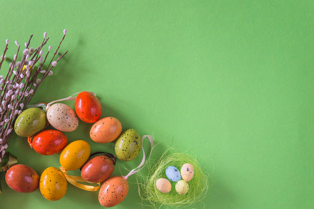 Easter eggs and willow twigs on a green background.