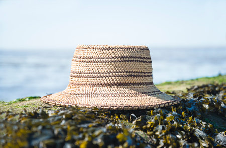 Straw hat on a rock near the sea. Selective focus.の写真素材