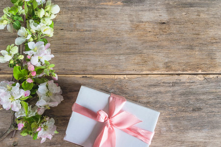 Gift box and spring blossom on wooden background with copy spaceの写真素材