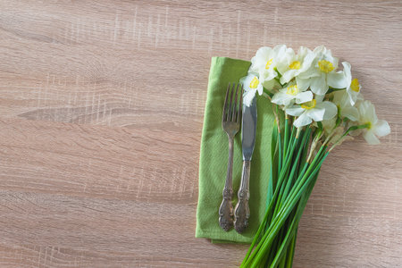 Spring table setting with daffodils on wooden background, top viewの写真素材