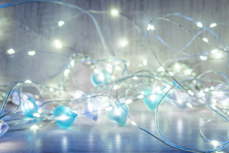Christmas lights on wooden background, bokeh effect. New Year