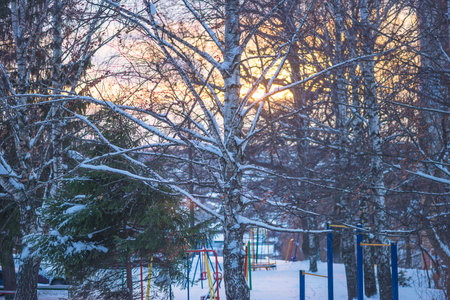 Winter playground in the city park at sunset. Beautiful winter landscape.の写真素材
