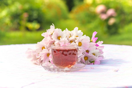 Cup of tea with spring flowers on a table in the gardenの写真素材