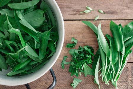 Fresh green ramson in a bowl on wooden background.Top view.