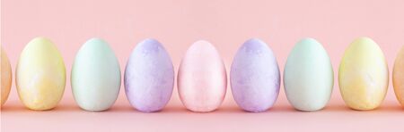 Row of pastel Easter eggs, on pink background.の写真素材