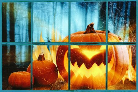 Scary halloween pumpkins , placed behind a window with scary backgroundの写真素材