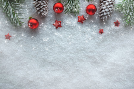 Christmas background with snow Christmas baubles and fir cones, view from aboveの写真素材