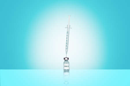 Syringe in an ampoule with Corona virus vaccine on blue backgroundの写真素材