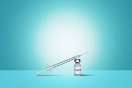 Syringe on a corona virus ampoule with a blue background
